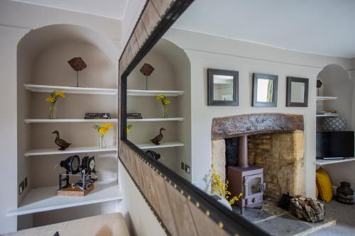 a living room with a fireplace and white shelves at No. 14, Park Street in Stow on the Wold