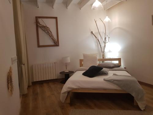 een slaapkamer met een bed in een witte kamer bij L'écurie in Saint-Germain-lès-Arlay