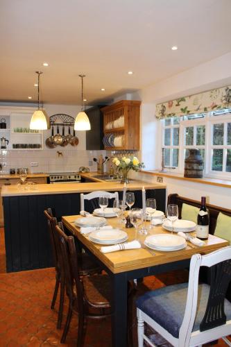 a kitchen with a wooden table with wine glasses at No. 14, Park Street in Stow on the Wold