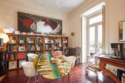 a room with a table and chairs and bookshelves at Ninho Salino in Cascais