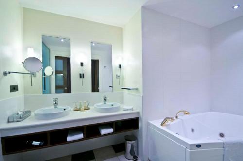 a bathroom with two sinks and a large mirror at Radisson Blu Hotel Paris, Marne-la-Vallée in Magny-le-Hongre