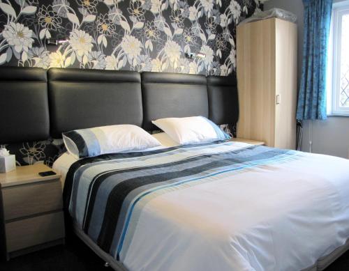 a bedroom with a large bed with a black headboard at The Loudor in Lincoln
