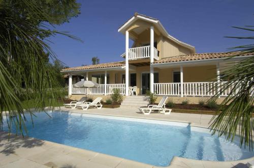 a house with a swimming pool in front of a house at Lagrange Vacances - Eden Parc Golf in Lacanau-Océan