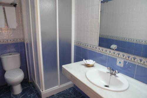 a bathroom with a sink and a toilet and a mirror at Chaikana in El Puerto de Santa María