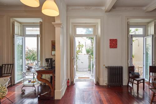 a living room with a table and a hallway with doors at Ninho Salino in Cascais