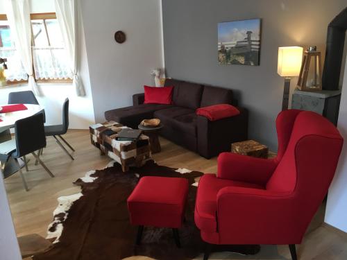 ミッテンヴァルトにあるALPENFREUNDのリビングルーム(ソファ、赤い椅子付)