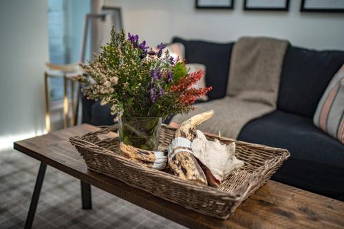 a wicker basket on a table with a vase of flowers at Pier House in Kinsale
