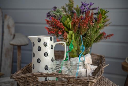 a table with a basket with a vase and flowers at Pier House in Kinsale