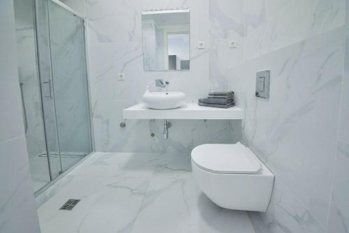 a white bathroom with a toilet and a sink at LUKA in Budva