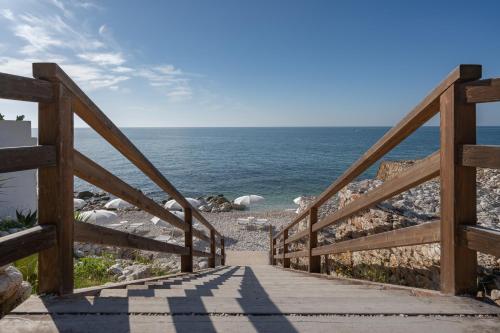 a wooden stairway leading down to the ocean at La Casa E Il Mare, Private Bay Hotel in Mattinata