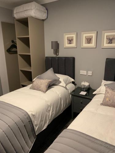a bedroom with two beds and a book shelf at The Royal Hotel in Stranraer