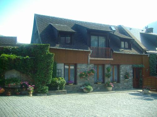 un edificio con plantas y flores delante de él en grand gite, en Cier-de-Luchon