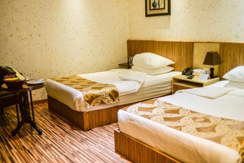 Ένα ή περισσότερα κρεβάτια σε δωμάτιο στο Palm Hotel