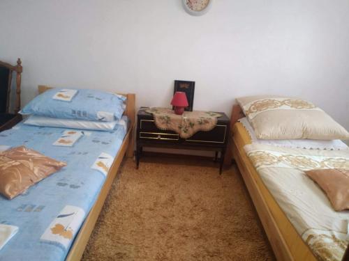 ein Schlafzimmer mit 2 Betten und einem Tisch mit einer Lampe in der Unterkunft Apartman Ana in Livno
