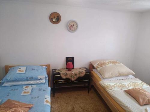 ein Schlafzimmer mit 2 Betten und einer Uhr an der Wand in der Unterkunft Apartman Ana in Livno