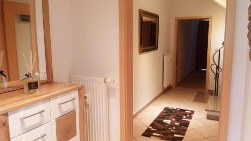 a kitchen with a sink and a mirror and a hallway at ALPENFREUND in Mittenwald
