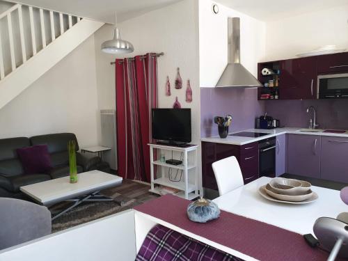 una cucina e un soggiorno con viola e bianco di Ma Maison a Le Château-dʼOléron