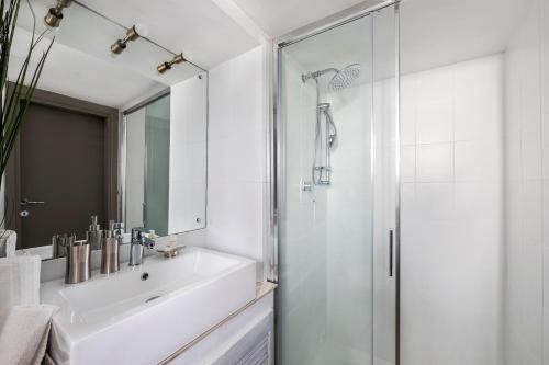 ein weißes Bad mit einem Waschbecken und einer Dusche in der Unterkunft iFlat Trastevere Bianca's House in Rom