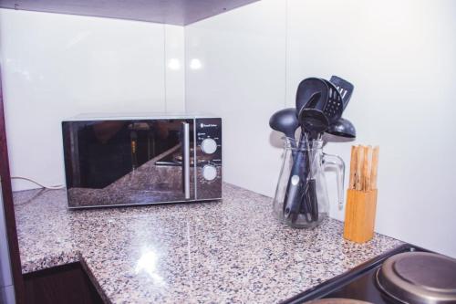 a kitchen counter with a microwave on a counter top at High Tide in Amanzimtoti
