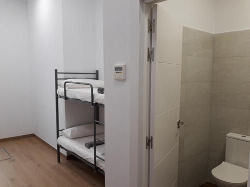 a small bathroom with a shower and a toilet at Hub Hostel Seville in Seville