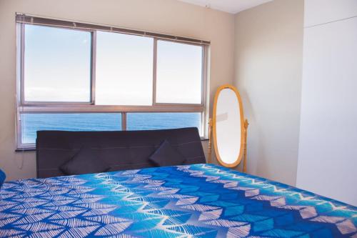 a bedroom with a bed and a mirror at High Tide in Amanzimtoti