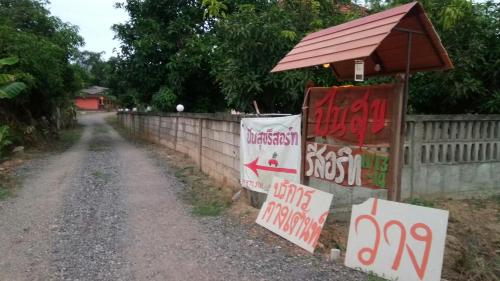 una recinzione con segnaletica sul lato della strada di ปันสุขรีสอร์ท a Loei