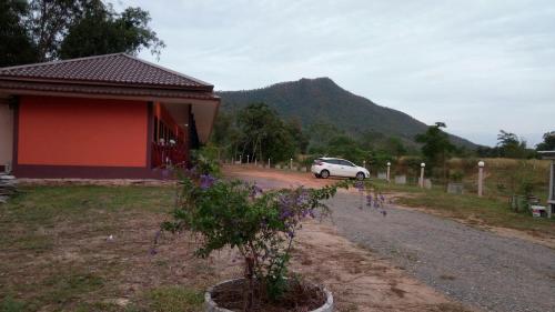 um carro estacionado numa estrada ao lado de uma casa em ปันสุขรีสอร์ท em Loei