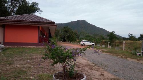 a car parked on a road next to a house at ปันสุขรีสอร์ท in Loei