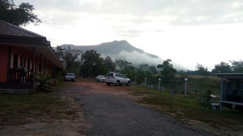 a car parked on a dirt road with a mountain at ปันสุขรีสอร์ท in Loei