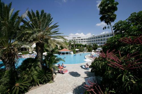 una vista de la piscina del complejo con personas sentadas en ella en Avanti Hotel, en Pafos