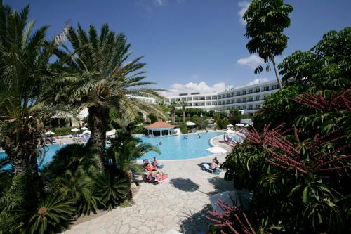 vista su una piscina del resort con persone sedute in essa di Avanti Hotel a Paphos