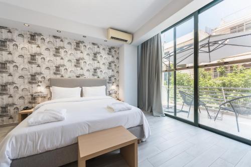 ein Schlafzimmer mit einem Bett und einem großen Fenster in der Unterkunft Athens Lights in Athen