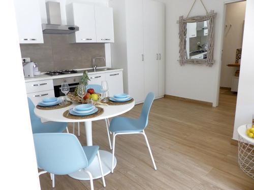 a kitchen with a white table and blue chairs at Nesh House in Syracuse