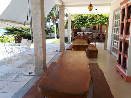 a patio with tables and chairs and an umbrella at Pousada Chic N Choc in Morro de São Paulo