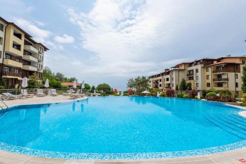 a large blue swimming pool in a apartment complex at Garden of Eden Complex in Sveti Vlas