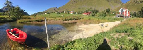 a red boat sitting on the side of a river at Lofoten Fjord Lodge in Saupstad