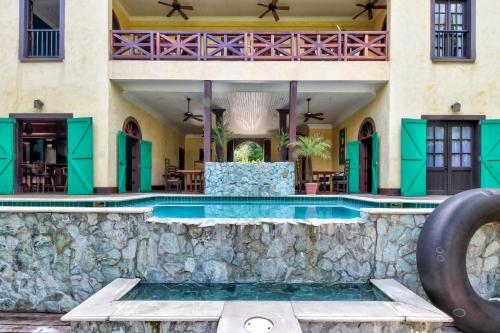 una piscina cubierta en una casa con una pared de piedra en Mahogany Hall, en San Ignacio