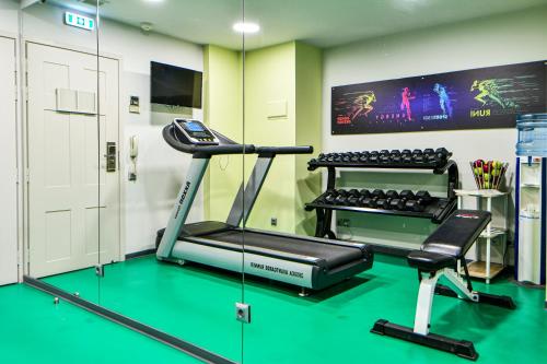 a room with a gym with a treadmill and a tv at Athens Tiare by Mage Hotels in Athens
