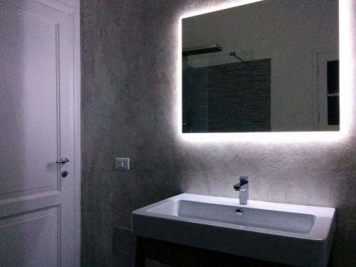 a bathroom with a white sink and a mirror at La Cinta in San Teodoro