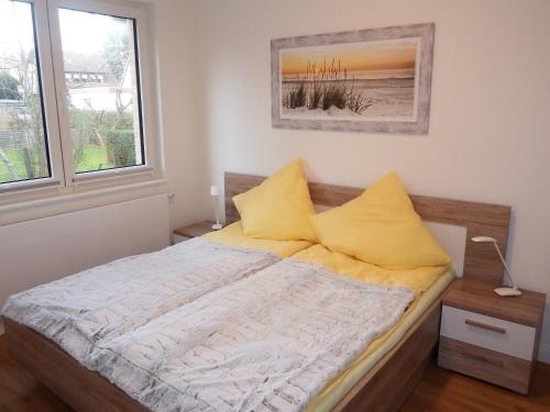 a bedroom with a bed with yellow pillows at Seestern in Hohwacht