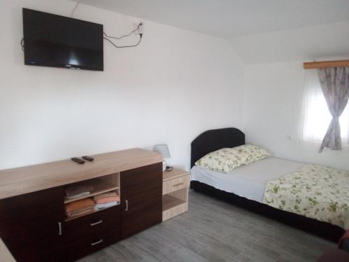 a bedroom with a bed and a tv on the wall at Apartmani "Babići" in Banja Luka