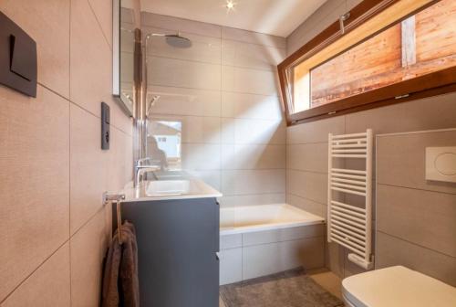 un baño con lavabo y bañera en K Terra 4, en Montriond