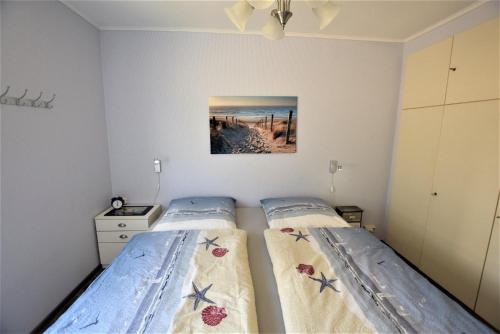 1 dormitorio con 2 camas y un cuadro en la pared en Hohes-Ufer-Sonnenkliff-Buggedei-30, en Hohwacht