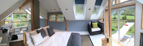 a bedroom with a bed in a room with windows at Lofoten Fjord Lodge in Saupstad