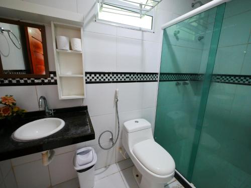 a bathroom with a shower and a toilet and a sink at Pousada Brasileira in Porto De Galinhas