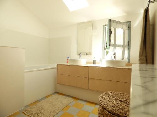 a bathroom with two sinks and a mirror at L’IMPASSE DES BATELIERS- magnifique maison pour 7 in Arles