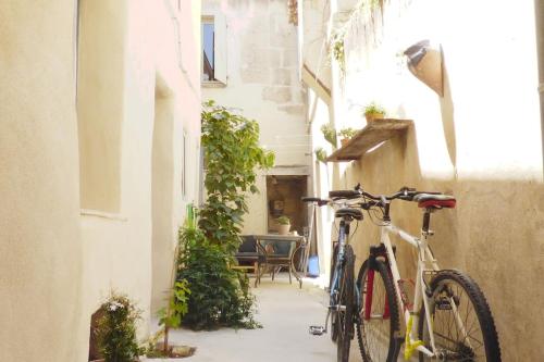 un vélo garé dans une ruelle à côté d'un bâtiment dans l'établissement Bateliers - Charme et Terrasse, à Arles