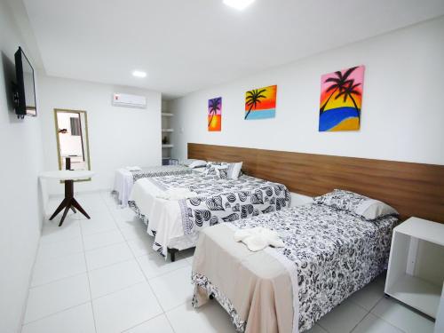 um quarto de hotel com duas camas e um espelho em Pousada Brasileira em Porto de Galinhas