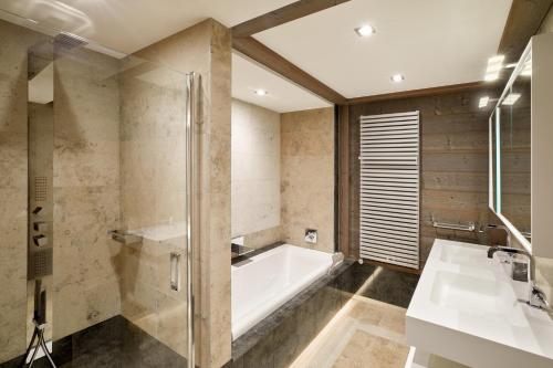 a bathroom with a tub and a sink at Six Senses Residences & Spa Courchevel in Courchevel