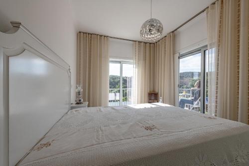 a white bedroom with a large bed and a window at Casa de Guribanes in Guribanes